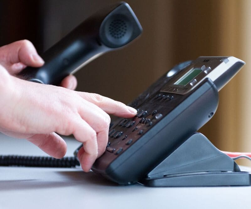 Man dialing a number on the Vonix VoIP desk phone
